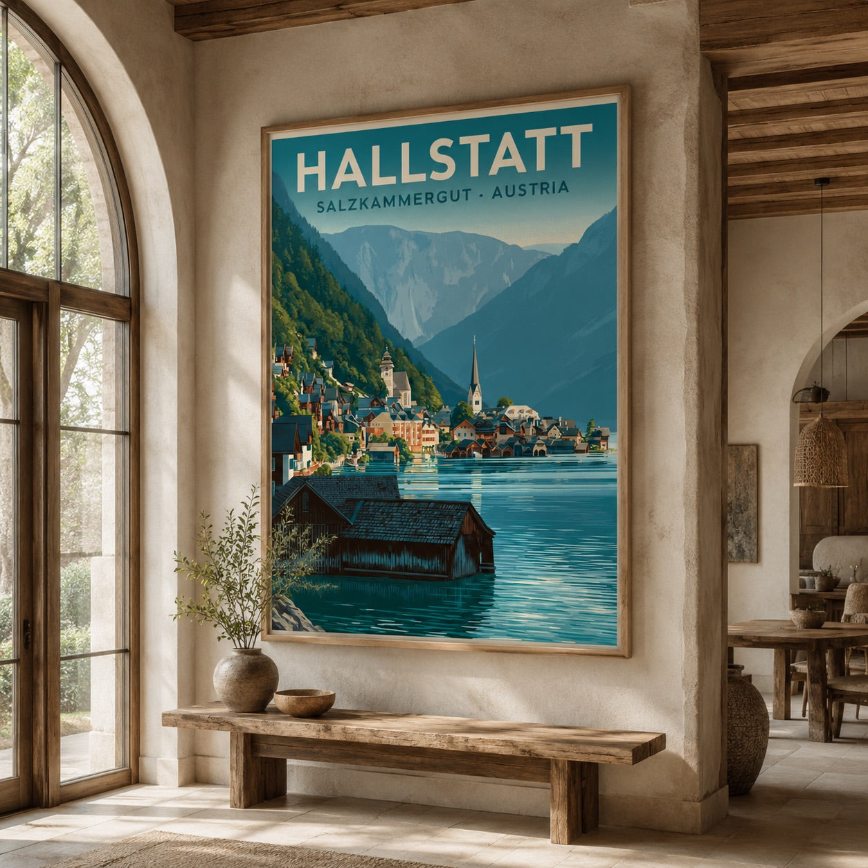 A framed travel poster of Hallstatt, Salzburgmergut - Austria, displayed on a beige plaster wall in a rustic, sunlit room with a wooden bench and arched windows.