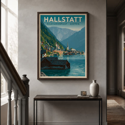 A framed travel poster of Hallstatt, Salzburg-Merggut, Austria, displayed on a light gray wall in a hallway above a console table with a vase.